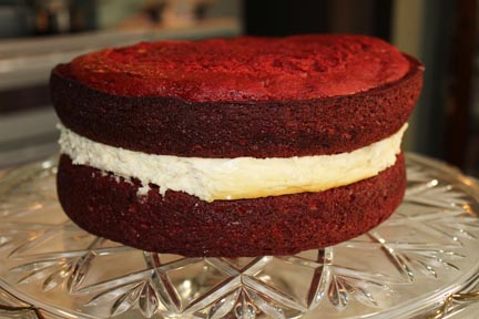 I got so busy putting the cake together, I skipped a few shots. Basically, let your cake cool, take your frozen cheesecake out of the freezer. Frost both the two sides of cake layers that will connect with the cheesecake and put them together.