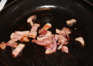 Start by frying a few strips of bacon, cut into small pieces.