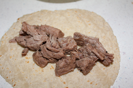 Shred your beef or cut it into pieces. Layer it on corn tortillas.
