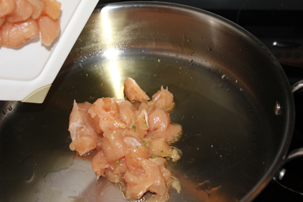 Add a little oil to the bottom of a large skillet and let it heat, then add chicken.