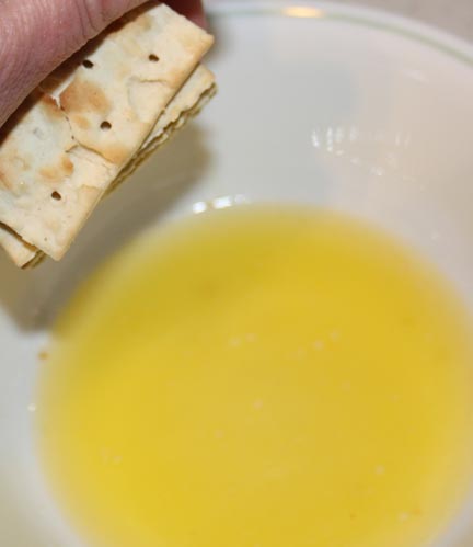 Melt the butter and crush, crumble or pulverize the crackers into the bowl.
