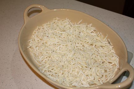 Grease a pan and add hash browns. Slide into oven as it preheats.